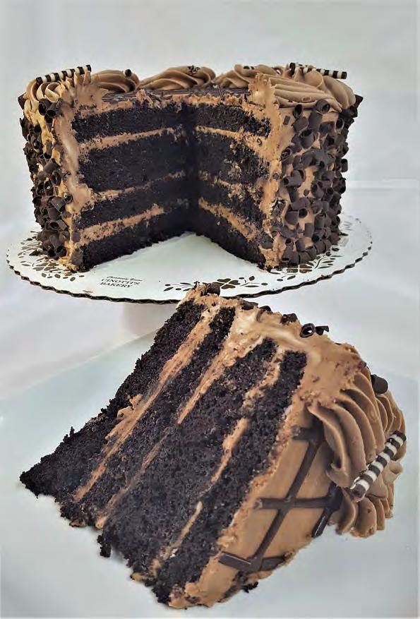 buttercream icing. Milk chocolate curls cover the sides.