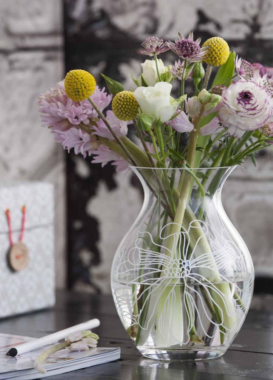 73 The Saga vase is made of clear glass with a white magnolia motif.