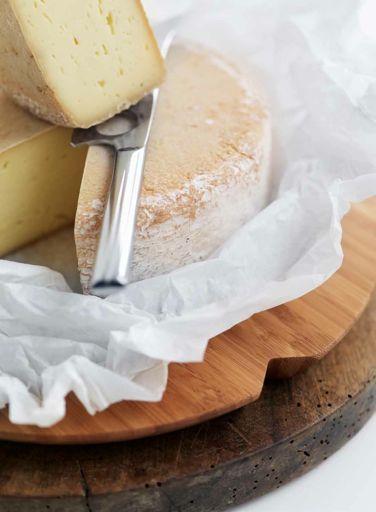23 Tasty cheese on a wooden chopping board