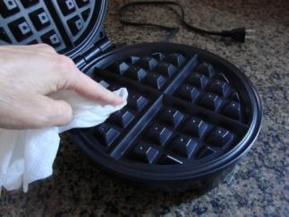 Squeeze it out gently so that it is still good and wet, but not so that it is still dripping Place the wet paper towel onto the hot waffle iron.