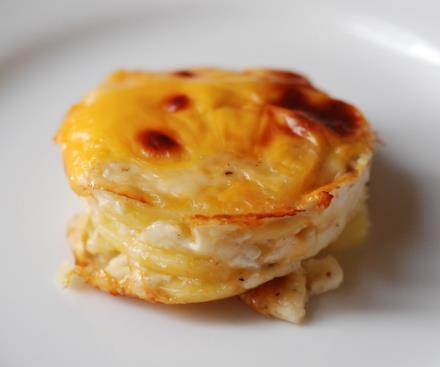 POTATO AU GRATIN Potato slices baked in a garlic creamy sauce with a golden layer of