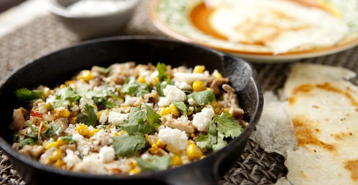 2 tablespoons olive oil 3 ears sweet corn 1/2 onion, diced 1-2 jalapenos, diced 2 cloves garlic, minced 1 pound chopped cooked chicken 1/2 lime, juice only Cotija cheese Fresh cilantro Hot sauce Red