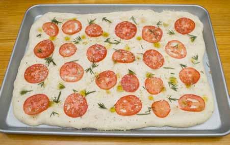 13 8 Slice the tomatoes really thin (a very sharp knife is crucial here) and arrange the slices on the dough.