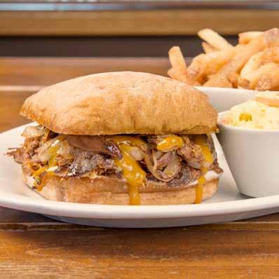 the abc famous SMOKEHOUSE SINCE 1999 $13.99 Melt-in-your-mouth smoked pulled pork, piled into a grilled sweet bun with sautéed onions, mayo and honey gold BBQ sauce.