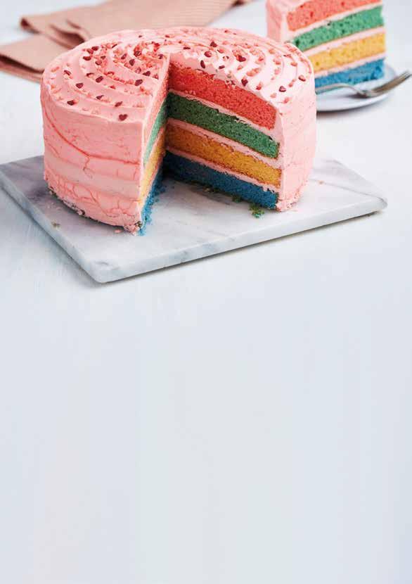 Valentines Rainbow Cake (7035) Serves 14-16 Four layers of rainbow coloured sponge sandwiched and covered with pink frosting, sprinkled with red sugar hearts and pink sugar pearls.