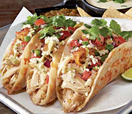 HANDHELDS GREEN CHILE CHICKEN TACOS Served in house-made cheese-crusted flour tortillas with green chile chicken, a