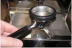 Using the provided cleaning brush and cleanser, clean the group head and be sure the groove that the gasket sits in is completely free of any residual gasket material and coffee grounds or the new