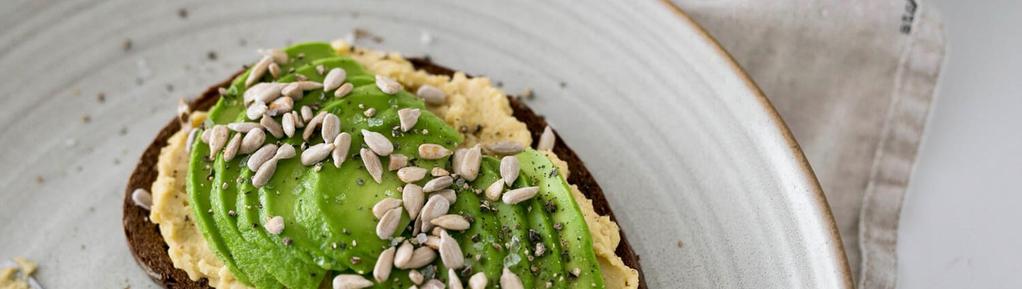Hummus Toast with Avocado 5 ingredients 10 minutes 2 servings Spread hummus over toast and top with avocado slices, sunflower seeds, salt and pepper. Enjoy!