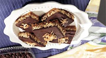 Triple Layer Cookie Bars 1 1/2 c. graham crackers crumbs 1/2 c. butter or margarine, melted 1 (7 oz.) pkg. flaked coconut (2 2/3 c.) 1 (14 oz.) can Eagle Brand milk 2 c.