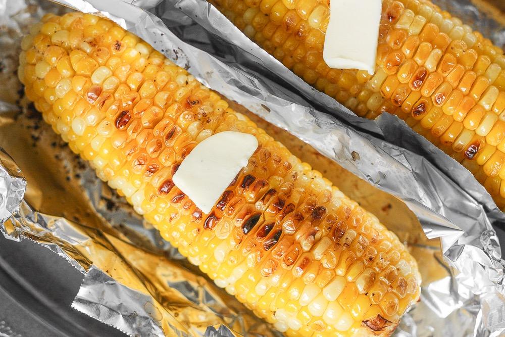 OVEN-ROASTED CORN ON THE COB 1/4 cup unsalted butter, softened 1 clove garlic, minced 1/4 teaspoon salt 1/8 teaspoon ground black pepper 4 cobs of corn, peeled 1. Preheat oven to 350 F. 2.