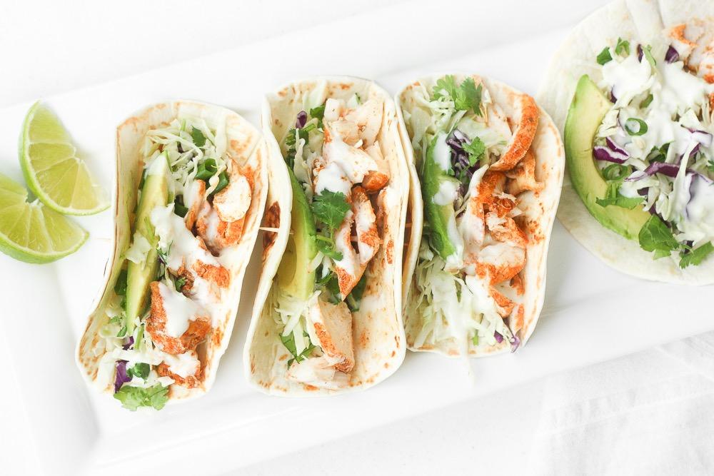 EASY FISH TACOS WITH LIME CREMA Lime Crema: 1/4 cup sour cream 3 tablespoons mayonnaise 1 tablespoon fresh lime juice zest from half a lime 1/4 teaspoon salt Slaw: 2 cups cabbage, shredded 1/4 cup