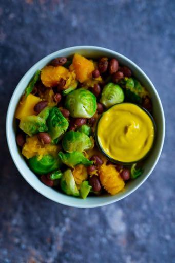 MAPLE GLAZED BRUSSELS SPROUTS 2 tsp olive oil 2 cups brussels sprouts, halved and outer layer removed 2 cups frozen butternut squash 1 pinch of sea salt 1 cup cooked kidney beans 2 tbsp maple syrup