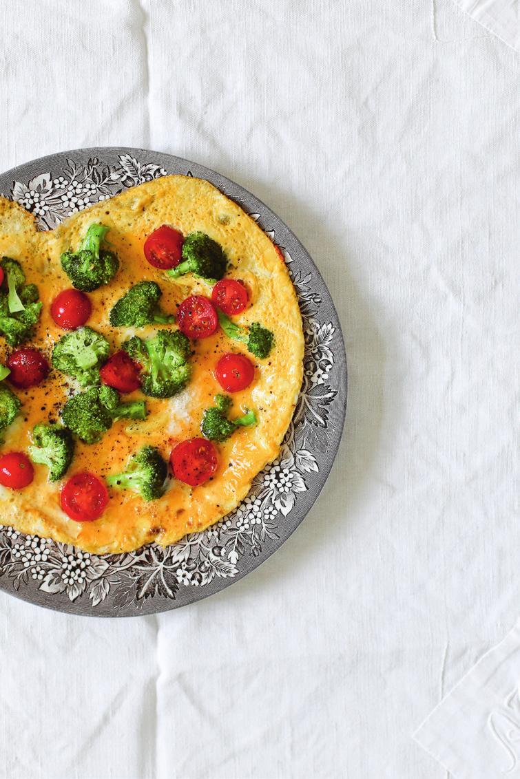 Pour it onto the hot saucepan and place the broccoli flowers and tomatoes on top. Cook on medium heat until the omelet looks firm and then flip it onto your plate.