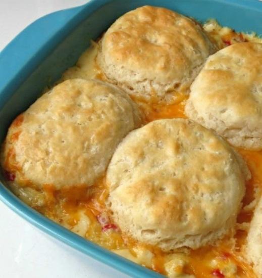 Chicken Biscuits Casserole 1 medium onion, chopped 1 1/2 teaspoons butter 4 cups Rotisserie chicken, chopped 1 small jar chopped pimiento 1 can cream of chicken soup 1 cup sour cream 1/2 cup milk 1