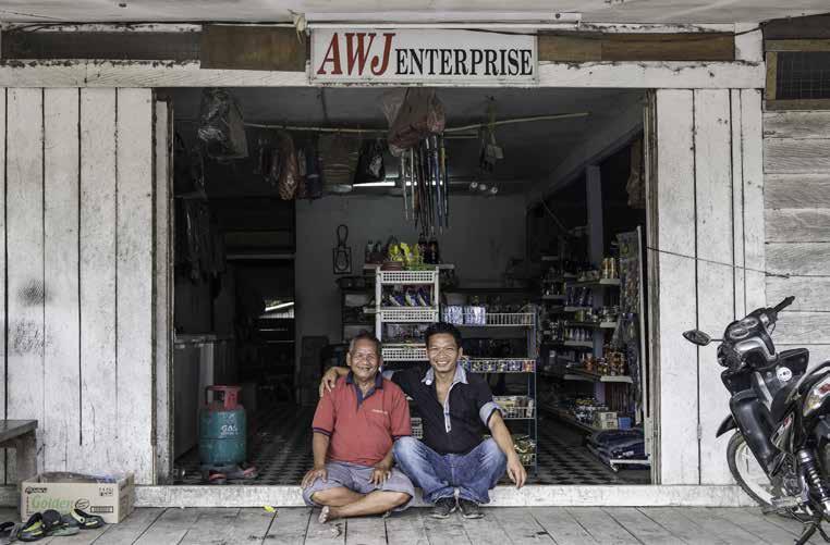 Frankie Anyit and his father pausing for a portrait in front of their sundry shop in Long Bedian, Sarawak.