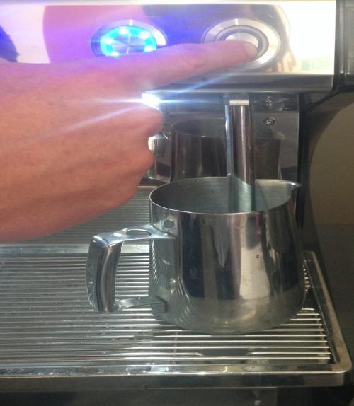 Place the pitcher under the barista steam wand with the arm submerged in