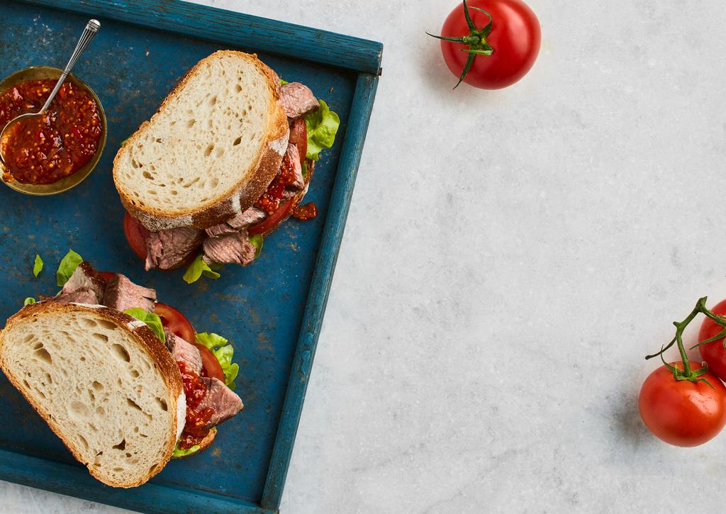 Steak Sandwich Serves 4 8 SLICES OF BAKERS DELIGHT AUTHENTIC SOURDOUGH VIENNA 2 LARGE SIRLOIN STEAKS SALT AND PEPPER TO TASTE 1 HEAD OAK LEAF LETTUCE, WASHED AND TRIMMED 2 TOMATOES, SLICED 100g