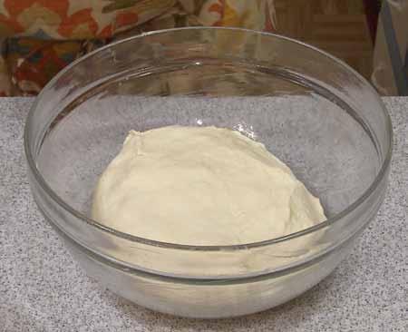 3 3 Place the dough in a greased or oiled bowl, cover with plastic, and set aside to rise until doubled, 1 to 2 hours.