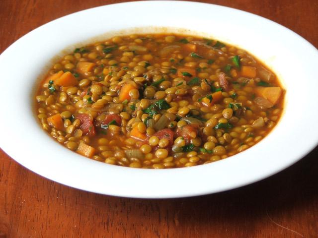 LENTIL SOUP Half of a large onion, chopped 4 garlic cloves, minced 2 tablespoons olive oil 2 carrots, chopped 2 celery ribs, chopped 1 teaspoon ground cumin 4 cups vegetable broth 1 cup French green