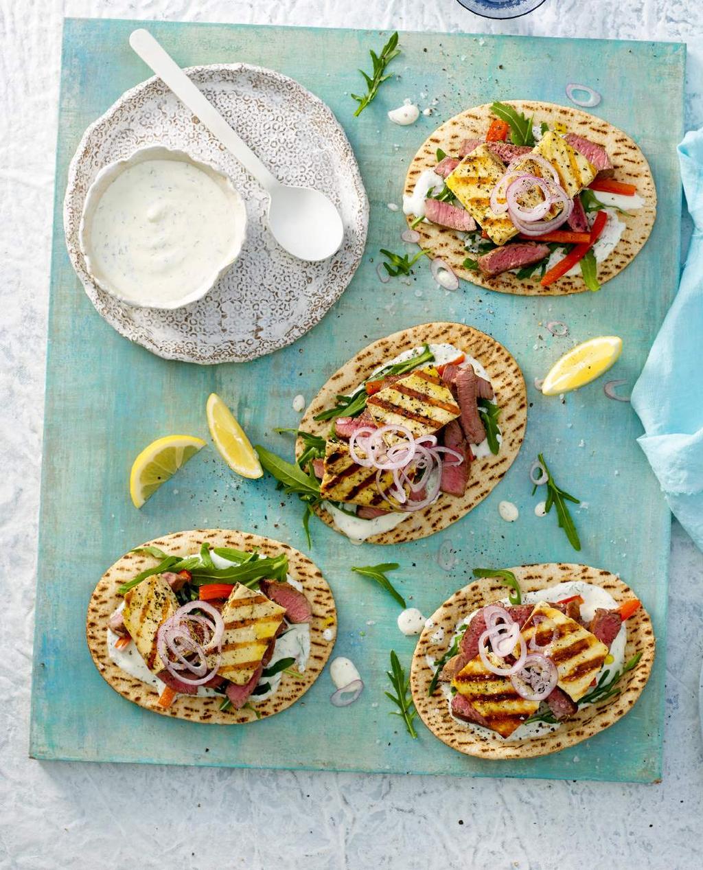Grilled Lamb and Haloumi Pitas Mini flat breads, filled with grilled tender lean lamb strips and golden Lime & Pepper Haloumi, red capsicum and a simple dill, garlic, and yoghurt sauce.