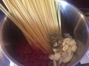 Bring the pot to a boil and using your tongs to curl the pasta into the liquid so it is full covered by liquid Place the lid on the saucepan and reduce to a gentle simmer Simmer the pasta for