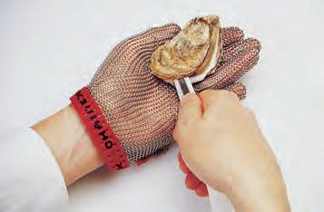 Rinse the shell under cold running water. Hold oyster in left hand, as shown. (Left-handers will hold oyster in right hand.) Hold the oyster knife near the tip as shown.