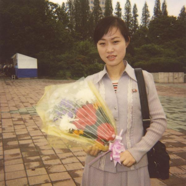 Her job is to sell flowers, which the visitors (including tourists) will lay in front of the Leaders statues in Mansudae hill in Pyongyang.