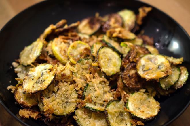 In a medium bowl, toss the zucchini with the oil. In a small bowl, combine the Parmesan, bread crumbs, salt, and a few turns of pepper.