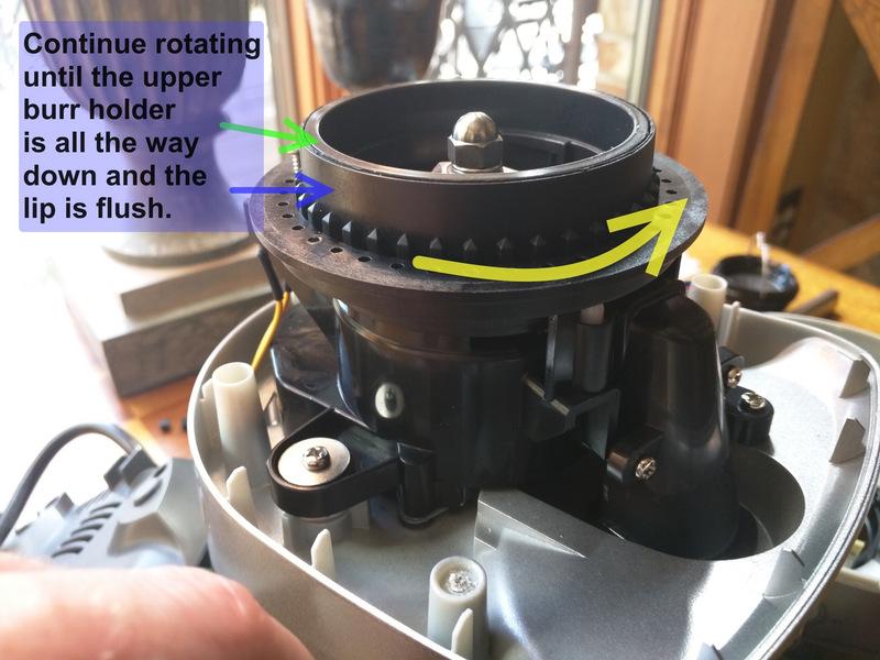 While pressing down with one hand, begin to rotate the grind adjuster in the direction shown by the arrow.