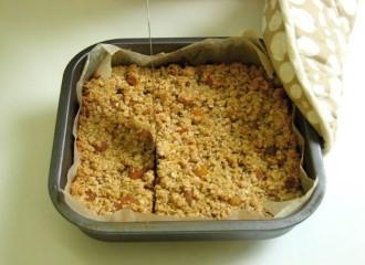Remove from the heat. 4. Stir in the oats and dried fruit. 5. Spoon the mixture into a foil tray. 6. Pat down the mixture in the tray. 7.