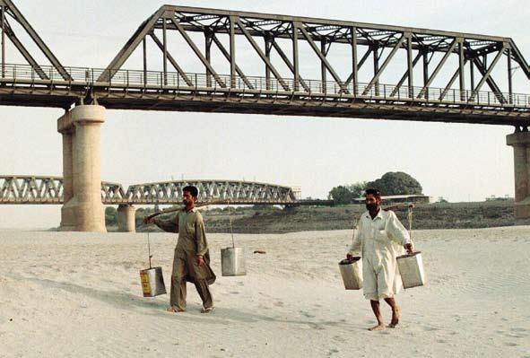 Người dân mang những chiếc bình rỗng đi trên một lòng sông khô cạn để tìm kiếm nước gần Hyderabad, cách Karachi khoảng 16