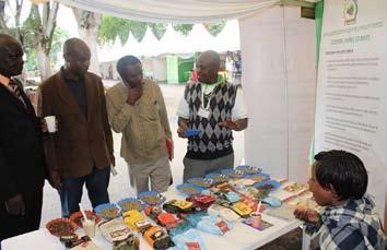 James Nzomo, AFFA s Officer (Coffe Directorate) - standing, right explains a point to visitors to the authority s exhibition during the W.T.O. Ministerial Conference & Expo that was held in Nairobi from Dec.