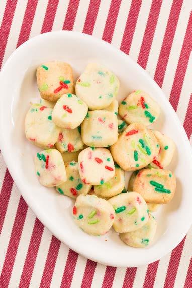 Add the red and green sprinkles and mix until combined. Line a 9x13 baking pan with parchment paper. Press the cookie dough into the bottom of the pan. Chill for 30 minutes. Preheat the oven to 350 F.