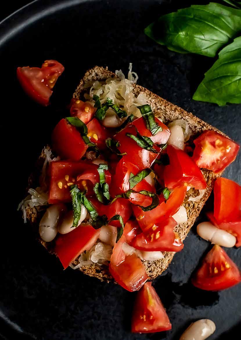 LUNCH SAUERKRAUT BRUSCHETTA 1 garlic clove, peeled and minced 4 tsp olive oil 4 slices wholegrain toast 3 tomatoes, chopped 3 heaped tbsp cannellini beans 200g / 2 cups fermented cabbage 3 tbsp
