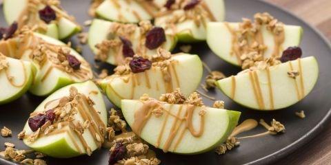 Peanut Butter Apple Nachos 2 Granny Smith apples, cored and cut into wedges 1/4 cup all natural peanut butter, warmed 2 tbsp. granola 1 tbsp. dried cranberries 1.