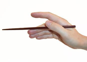 This chopstick shouldn't touch the forefinger. 2. Place the other chopstick between your thumb and forefinger.