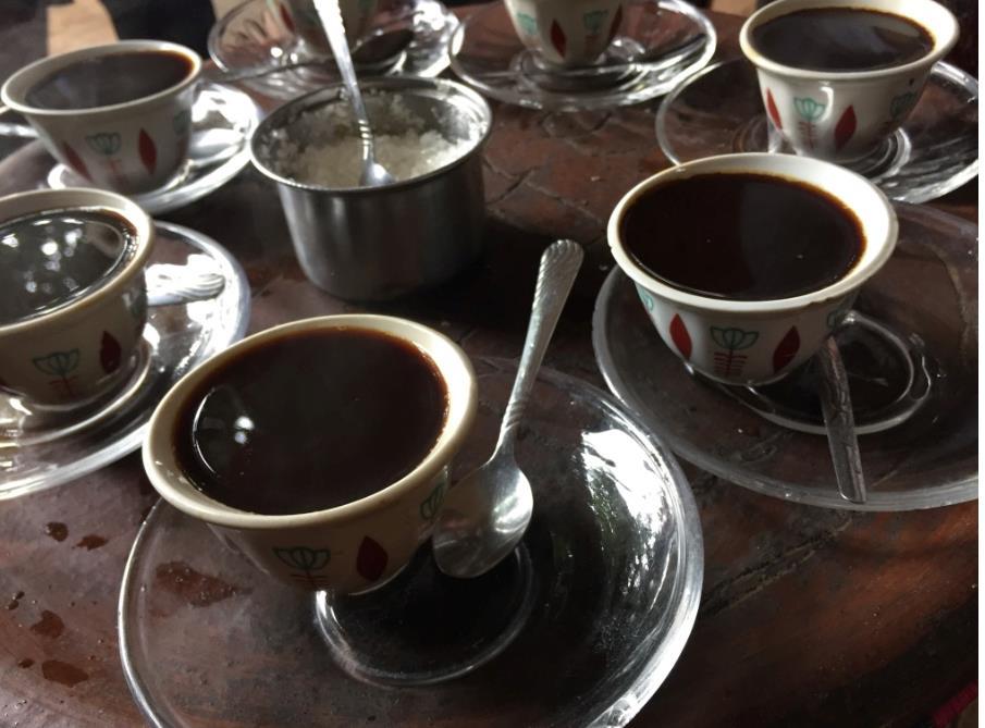 Coffee is served in small cups with coarse sugar.