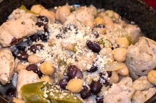 5 oz) can chicken broth 3 cups chopped cooked chicken breast 3 (15 oz) cans white beans (1 crushed) 1 can black beans 1 cup shredded Monterey Jack cheese Heat the oil in a large saucepan over