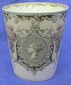 A Royal Doulton 3.8 inch by 3.3 inch beaker with multicolour pattern on white china. England. Rd.293418 (1897). Referenced in: 1327x. Latest retail valuation (26/02/2005) 50.