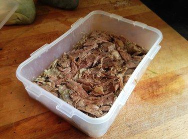 Place the cooked lamb in to a container and flatten down as much as possible.
