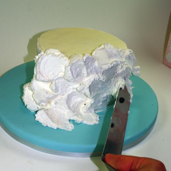 Form a disk of white sugar paste, cut it out with a pastry cutter and place it over the cake. 2.