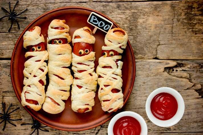 Mummies Makes 8 Mummies 8 Hot dogs or sausage links 1 Package of premade pizza dough, sliced into strips (a pizza cutter is excellent for this) Mustard for eyes (optional) Preheat oven to 350 degrees.