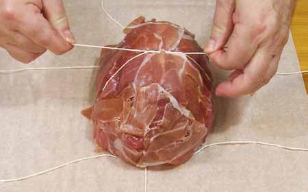 18 11 Carefully bring up the prosciutto slices to encase the duck loaf and secure into place with the kitchen string.