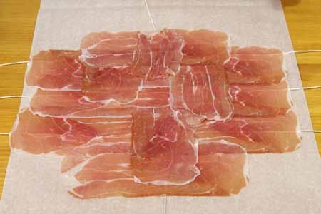15 Carefully arrange the prosciutto slices on top of the strings, overlapping them.