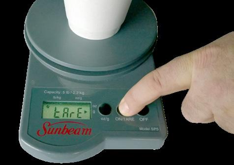 . Tare receiving container or cup on digital weigh scale.