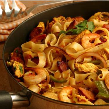 Quick Pasta Paella Rice pasta replaces conventional rice in this piquant flavored dish. Quickly cooked chicken tenders and precooked seafood help speed this paella to the table.